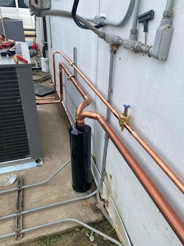A copper pipe is being installed on the side of a building.