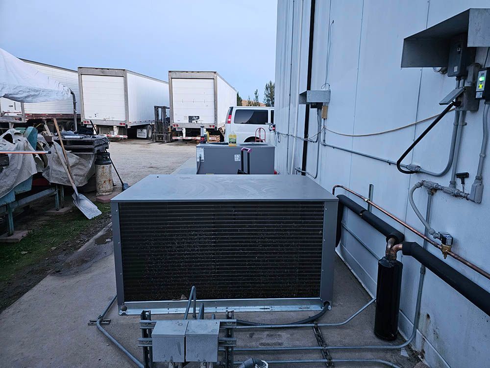 A large air conditioner is sitting on the side of a building.