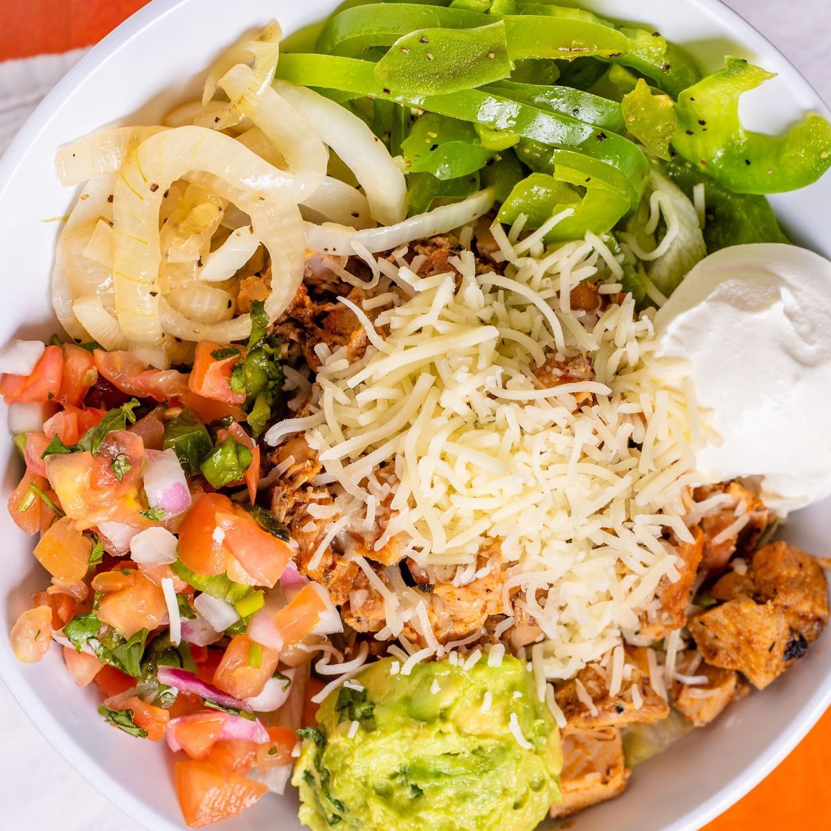 A white bowl filled with a variety of vegetables and cheese
