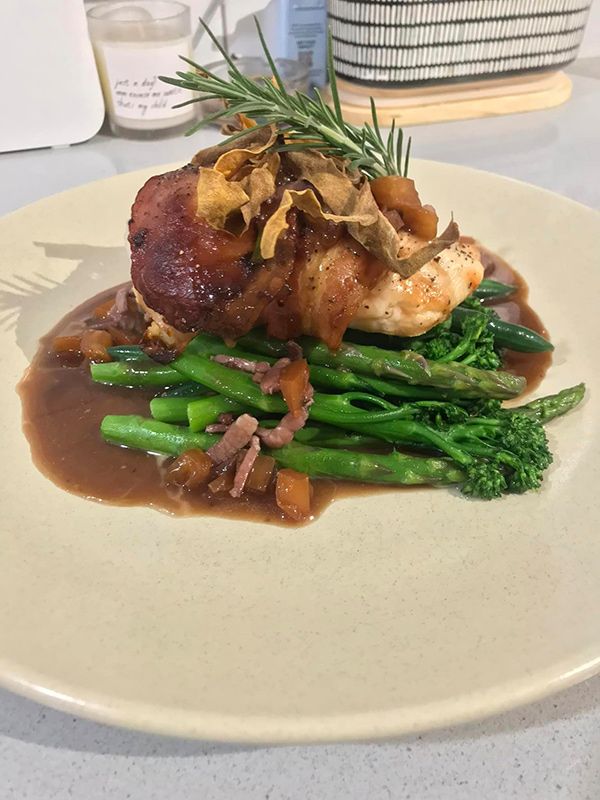 A White Plate Topped with Chicken, Asparagus, and Sauce on A Table — Every Occasion Catering in Scone, NSW