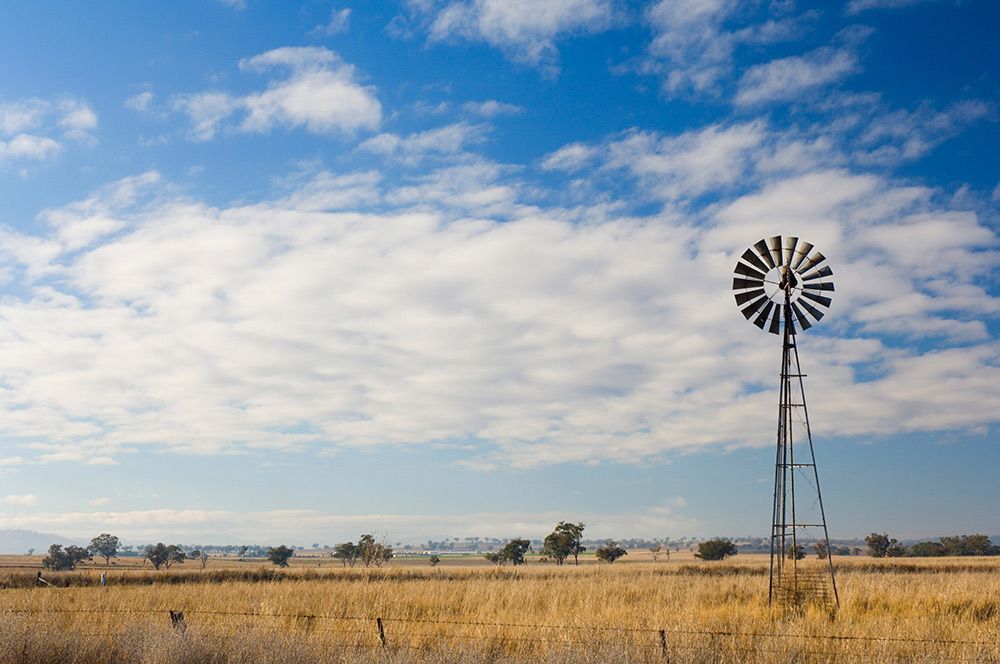 A Windmill in The Middle of A Field with A Blue Sky in The Background — Every Occasion Catering in Manilla, NSW