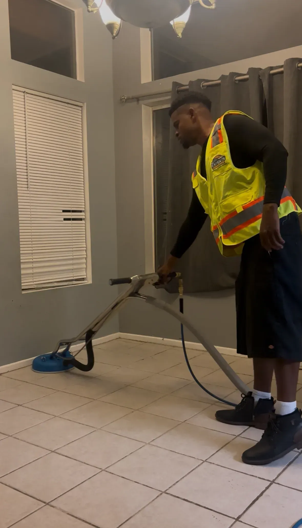Five construction workers in hard hats and vests, smiling, posing in a building.