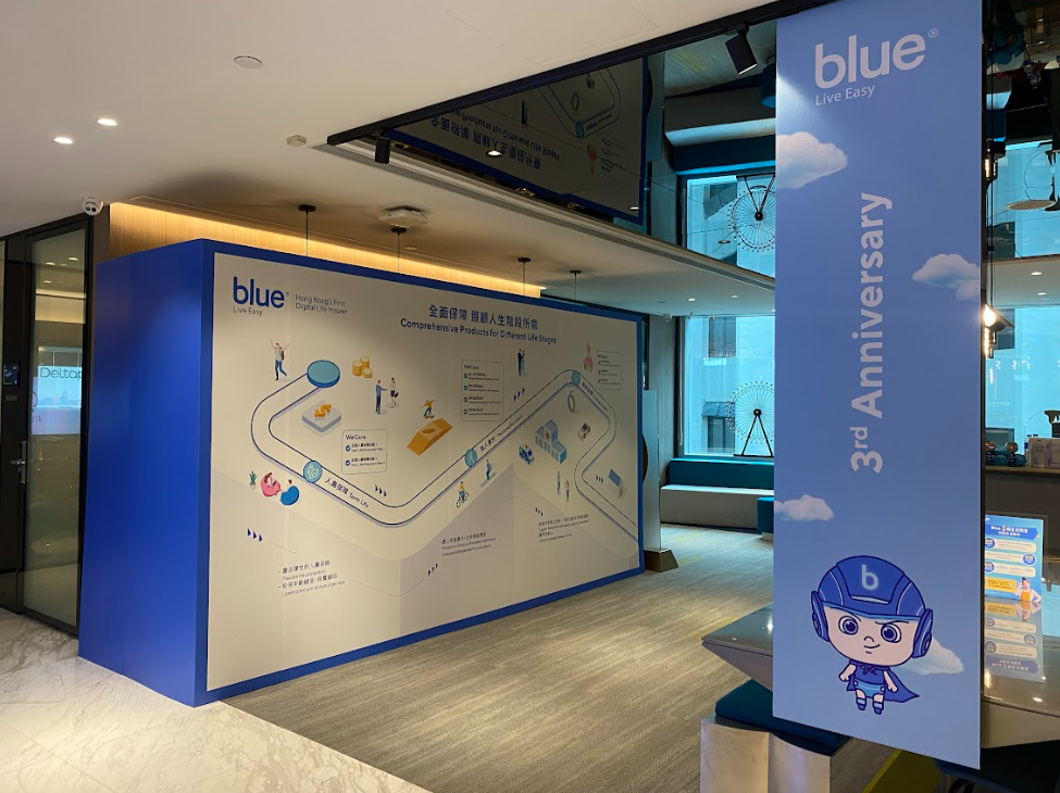 Blue Factory 3rd Anniversary display with cartoon character and a map on the wall.