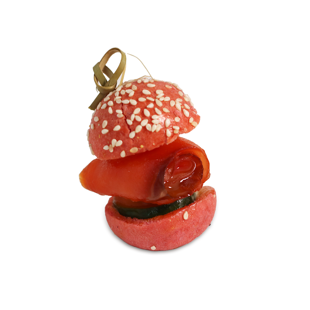 Red appetizer on skewer with sesame seed bun and salmon.