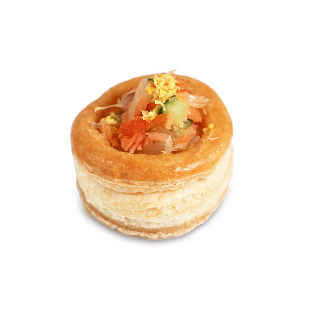 Vol-au-vent pastry filled with diced salmon, cucumber, and a garnish, on a white background.