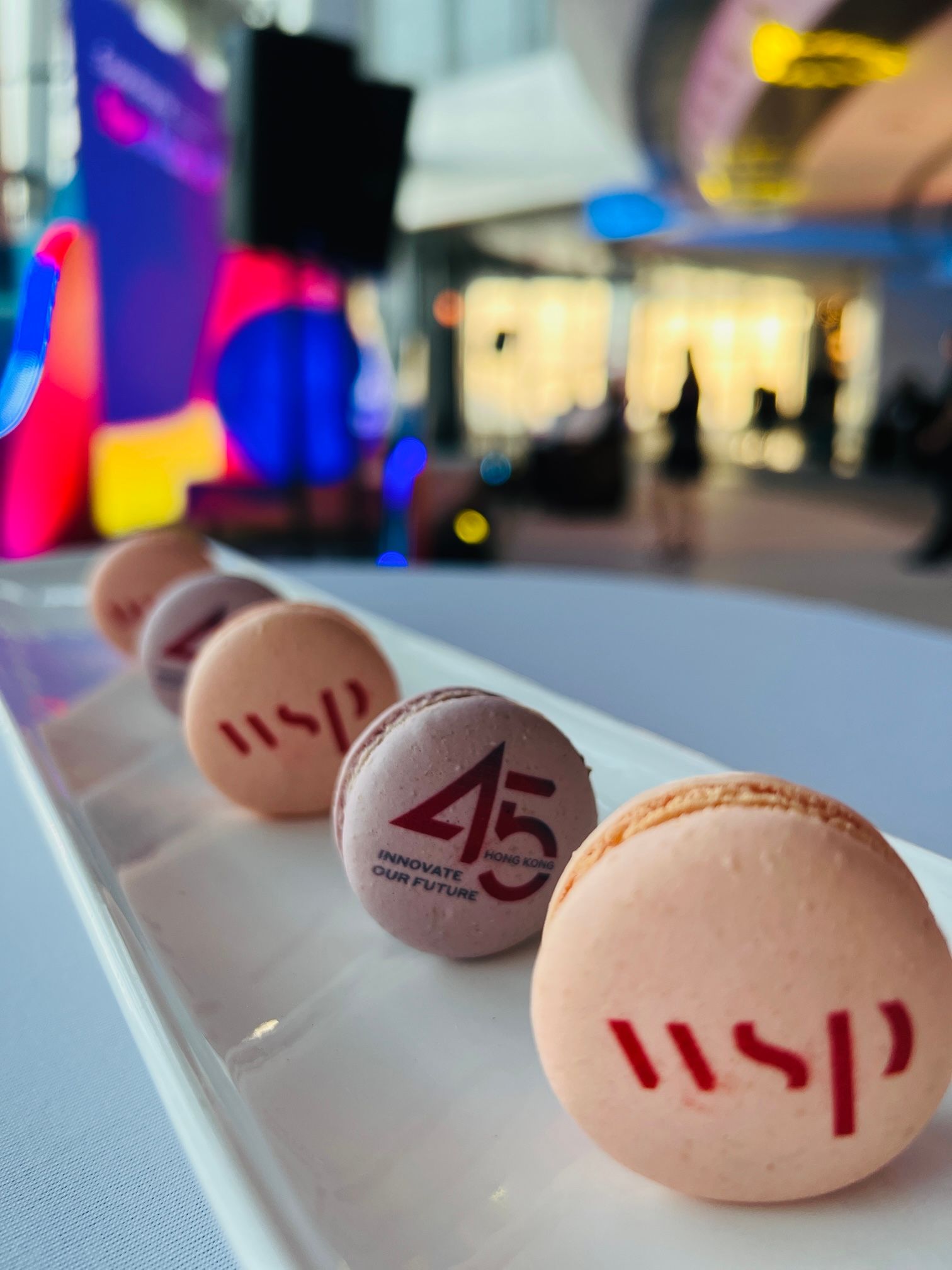 白色盤子上擺放著一排色彩柔和的馬卡龍，上面印有「WSP」標誌和「45」週年紀念訊息。