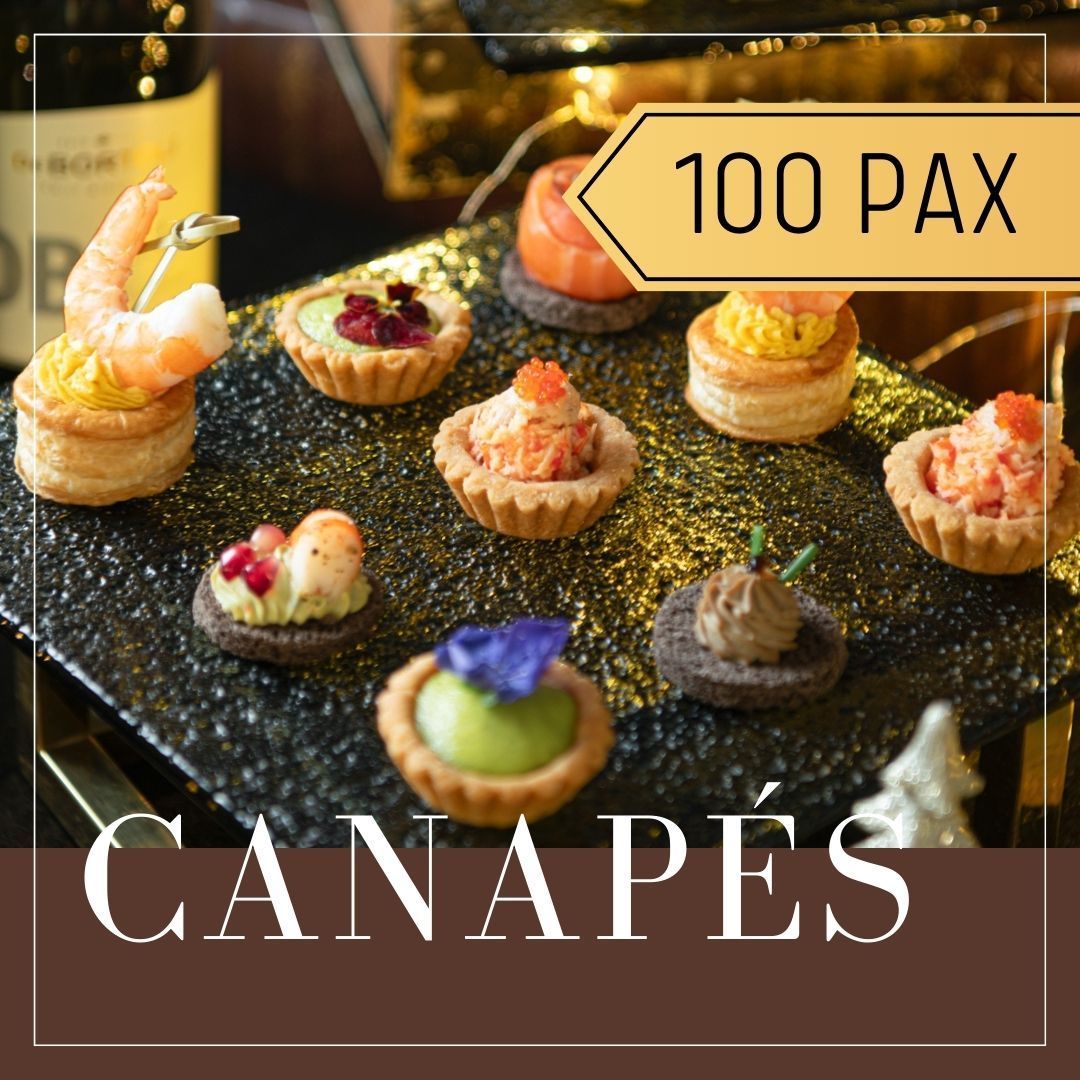 Assorted canapés on a black platter, with