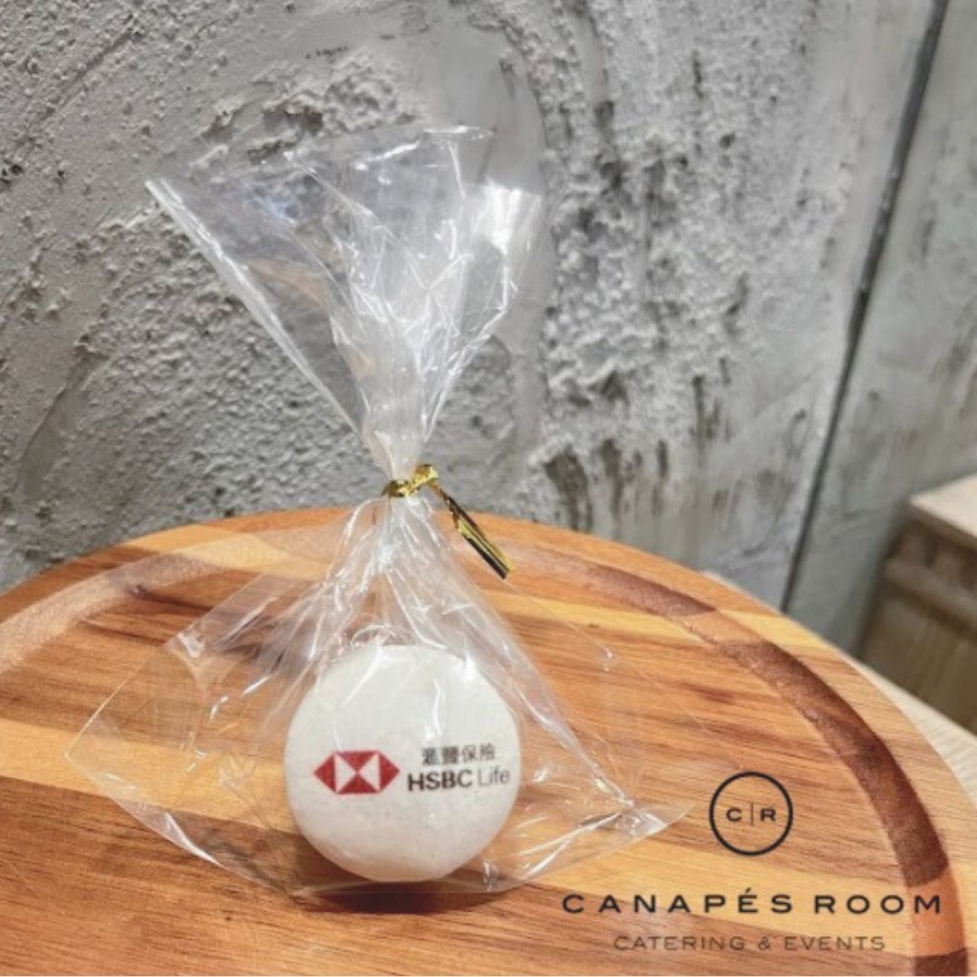 帶有匯豐人壽標誌的白色球體，用透明塑膠包裹，用金繩繫住，放在木板上。