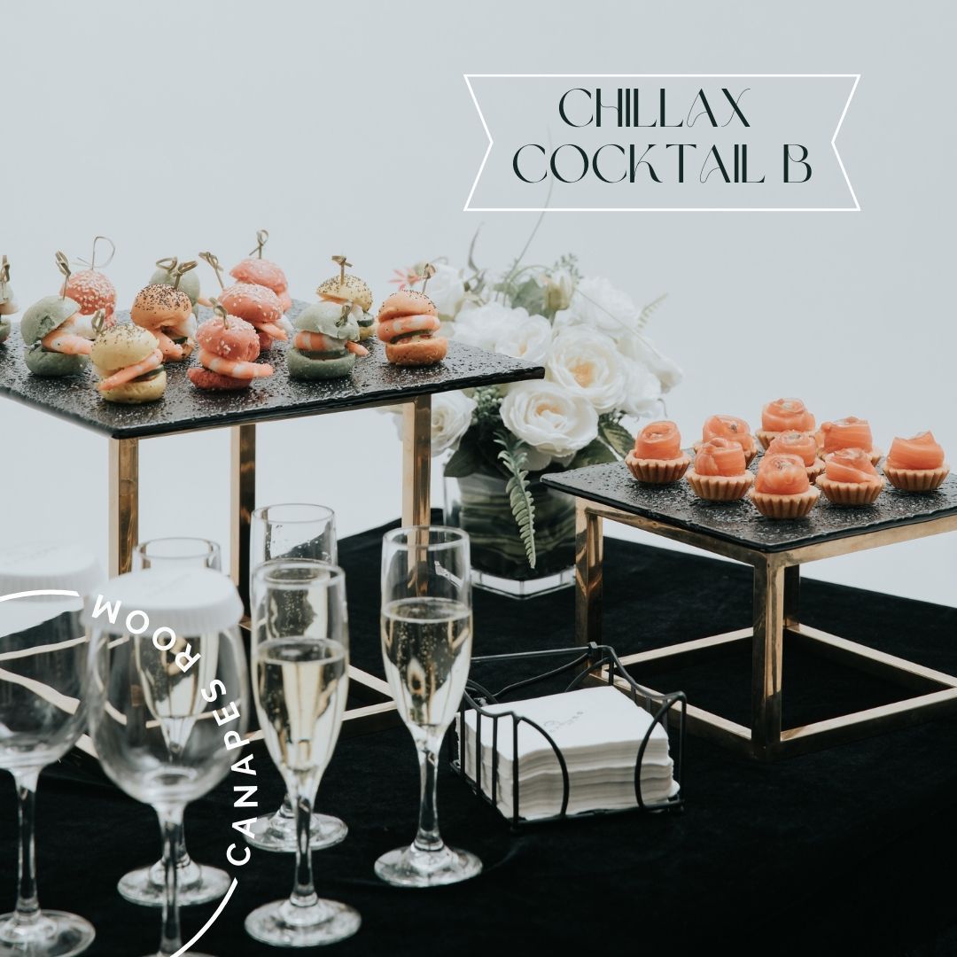 雞尾酒食物展示：分層盤子上的開胃菜、香檳杯和黑色桌布上的餐巾。