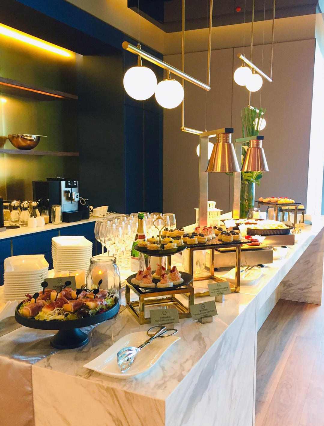 Buffet with appetizers, lighting, and marble countertop.