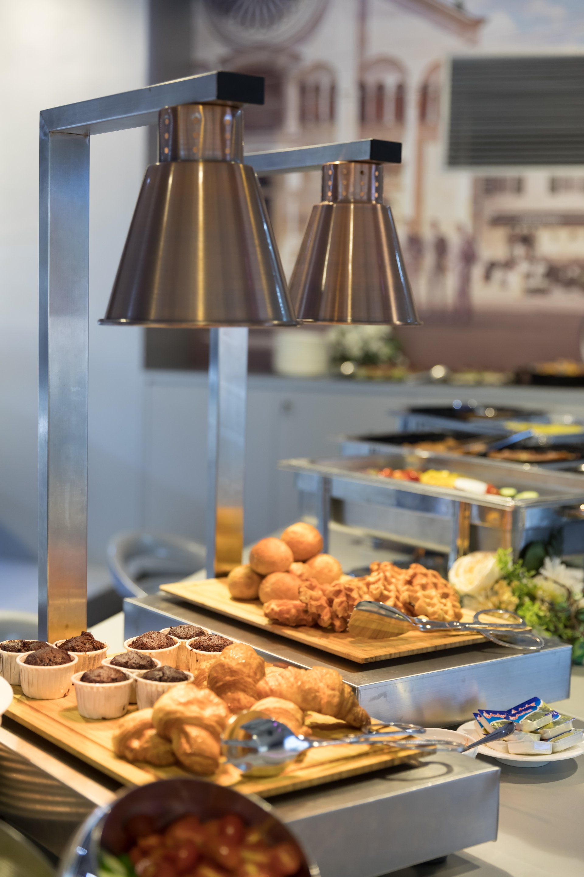自助餐檯，食物在加熱燈下供應。烘焙食品和其他菜餚均在展示中。