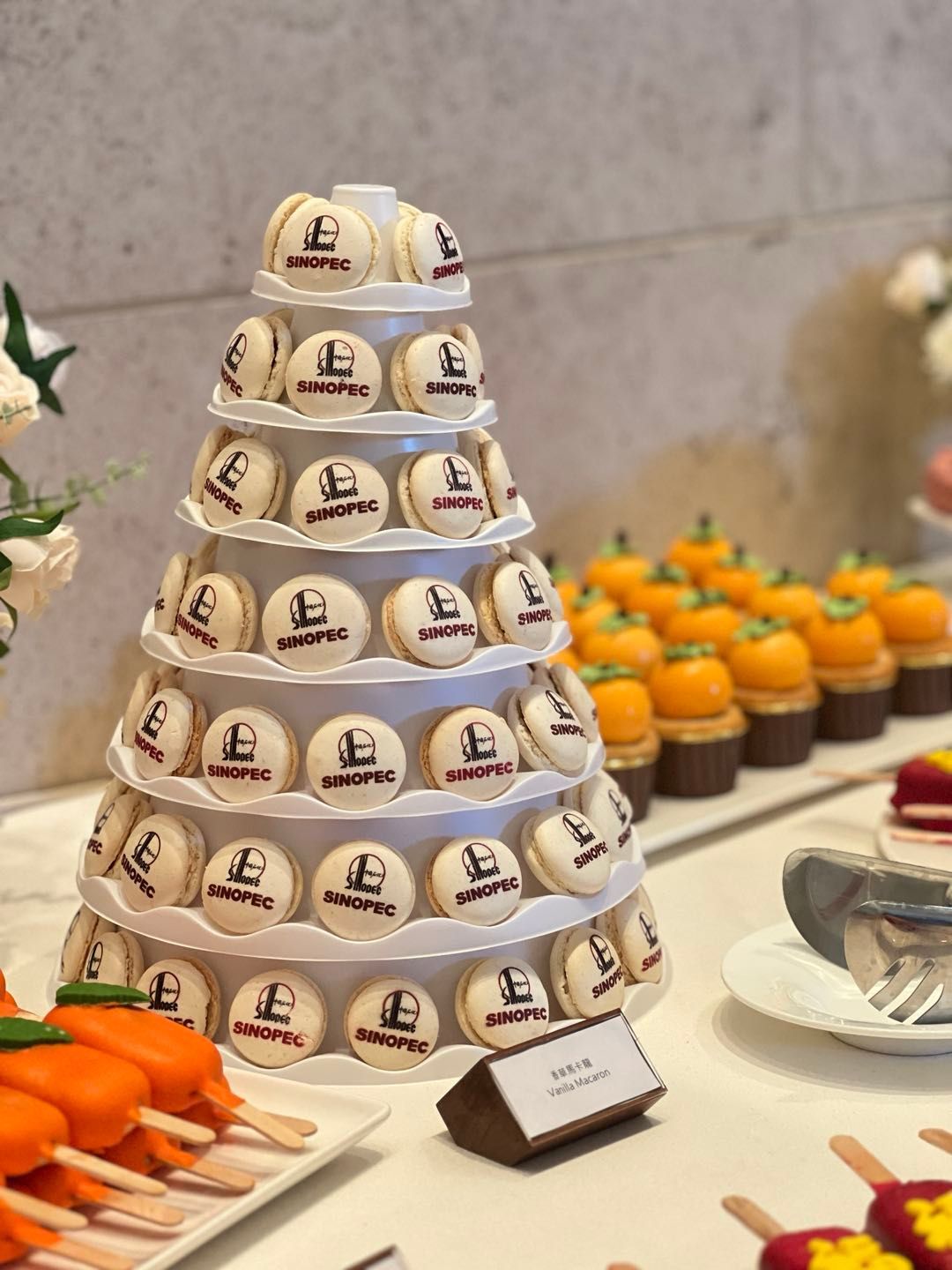 自助餐上有帶有標誌的馬卡龍塔、迷你南瓜紙杯蛋糕和其他甜點。