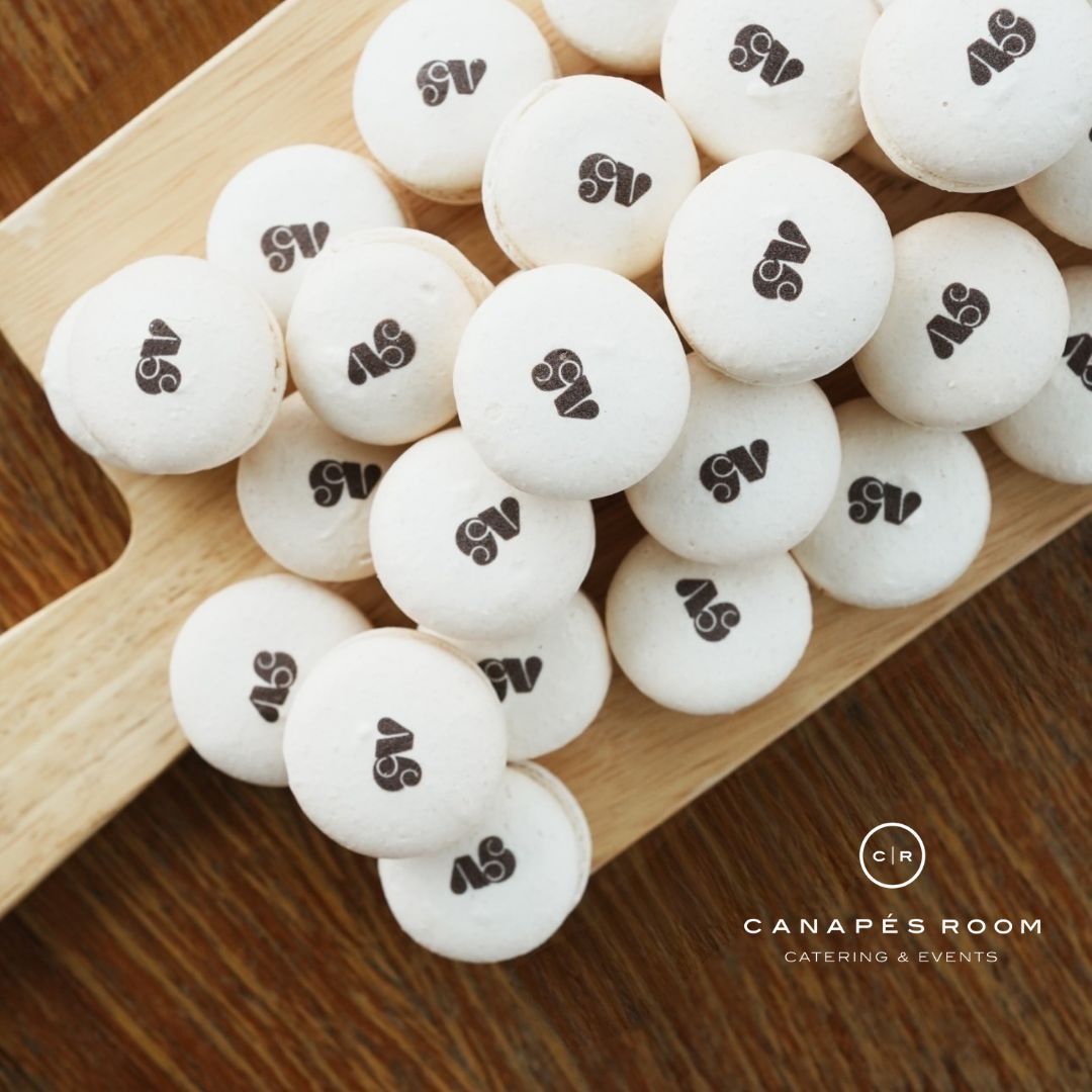 白色的馬卡龍上面印著“AS”，排列在木板上。