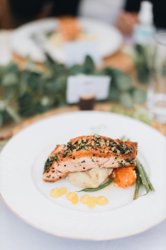 Salmon fillet with mashed potatoes, carrots, and beans on a white plate.