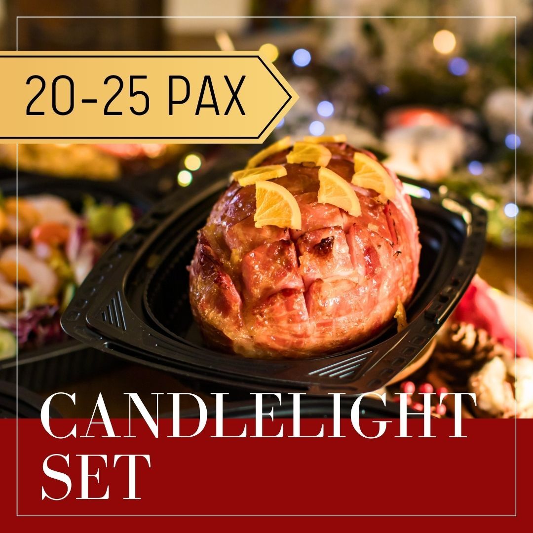 Candlelight set with ham for 20-25 people. Ham garnished with orange slices. Festive setting with red and gold tones.