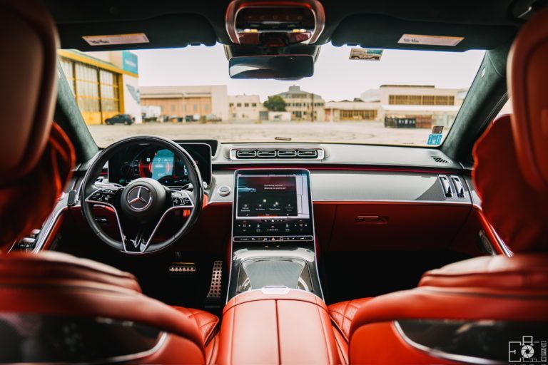 The inside of a car with red seats and a steering wheel.