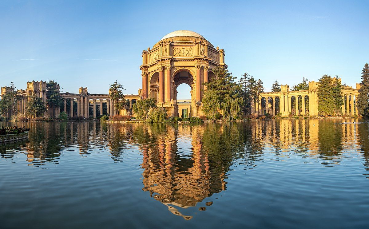 A large building is reflected in a body of water.