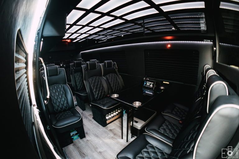 Executive Sprinter interior with black quilted group seating and table