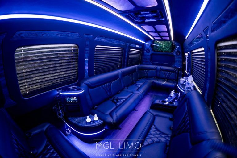 Interior of a black limousine with blue LED lighting and leather seating.