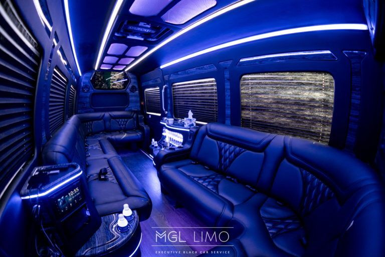 Interior of a party bus with blue LED lighting and leather seating.