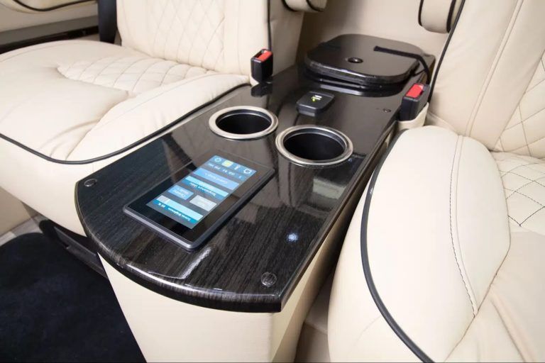 A tablet sits on a table in the back seat of a car
