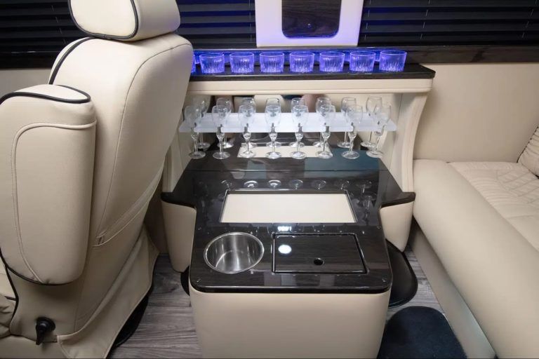 A table in the back of a car with wine glasses on it.