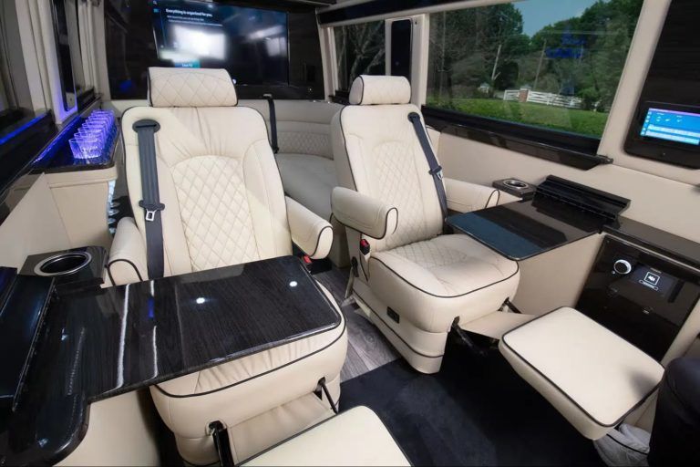 Luxury Jet Sprinter interior with white leather seating and tables