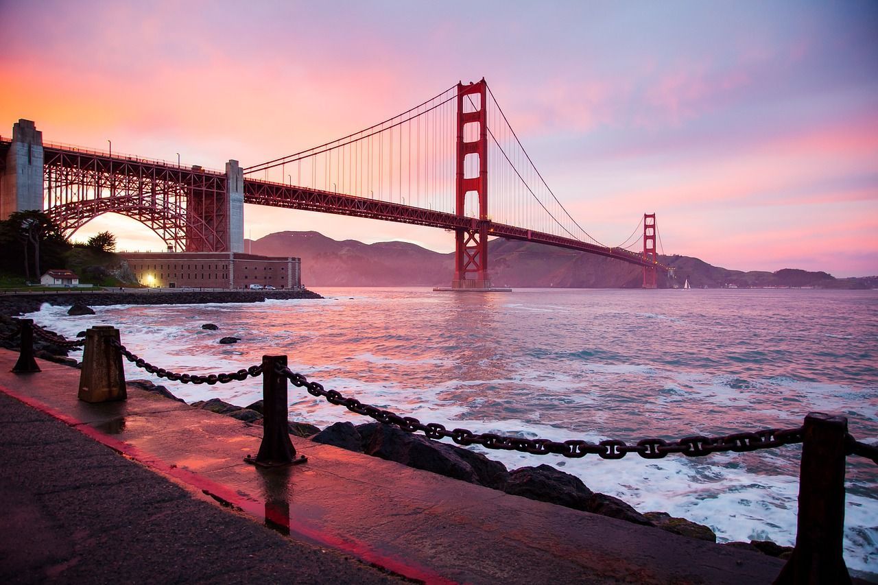 A bridge over a body of water with a sunset in the background.