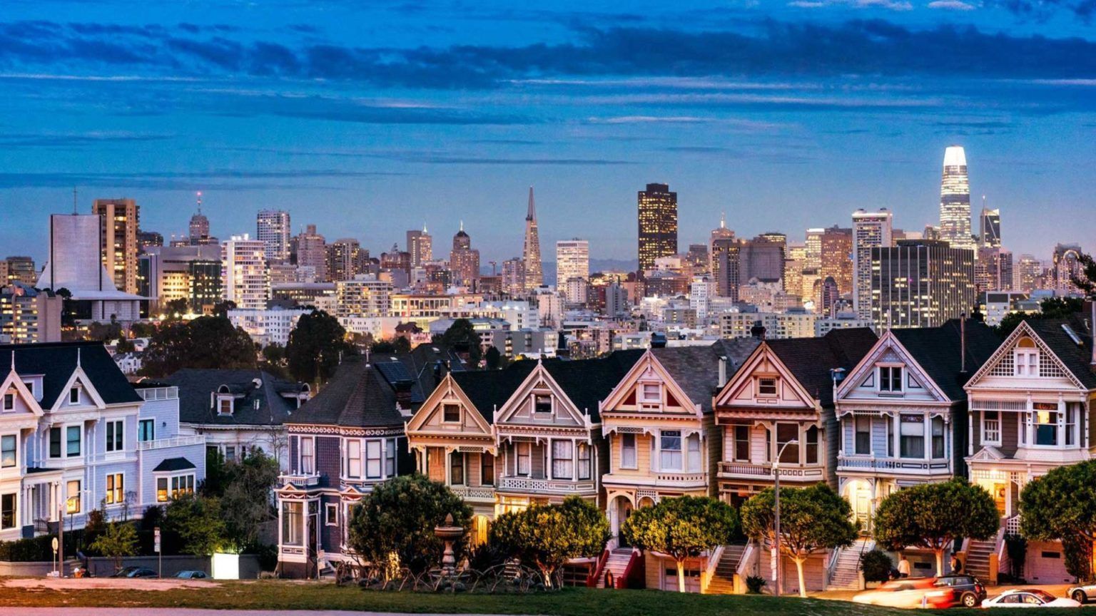 A row of houses with a city skyline in the background