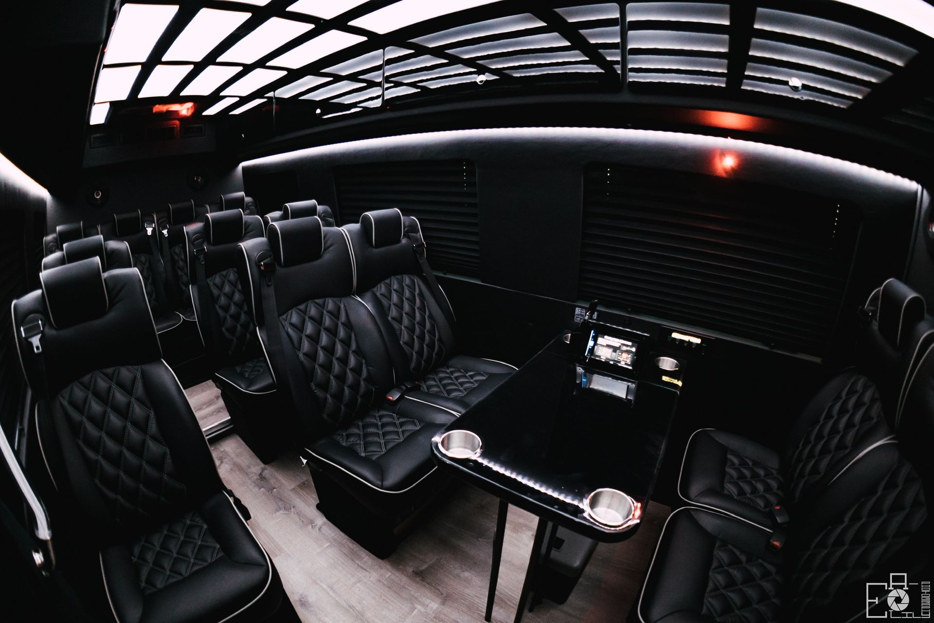 The inside of a bus with black seats and a table