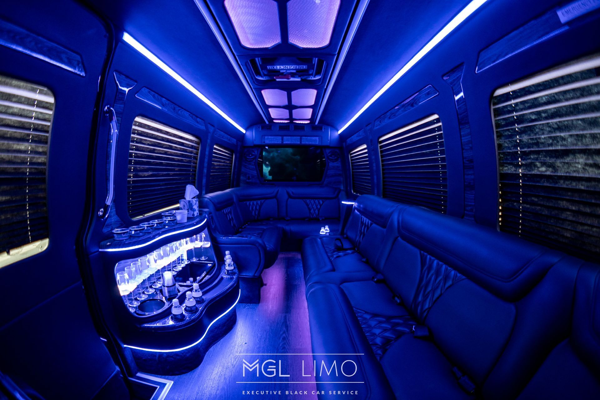 Interior of a limousine with blue LED lighting and dark leather seating.