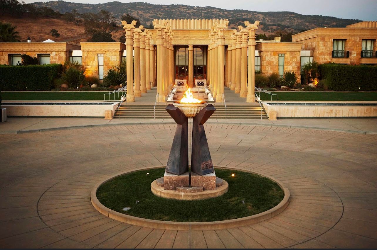 A statue of hands holding a torch in front of a building