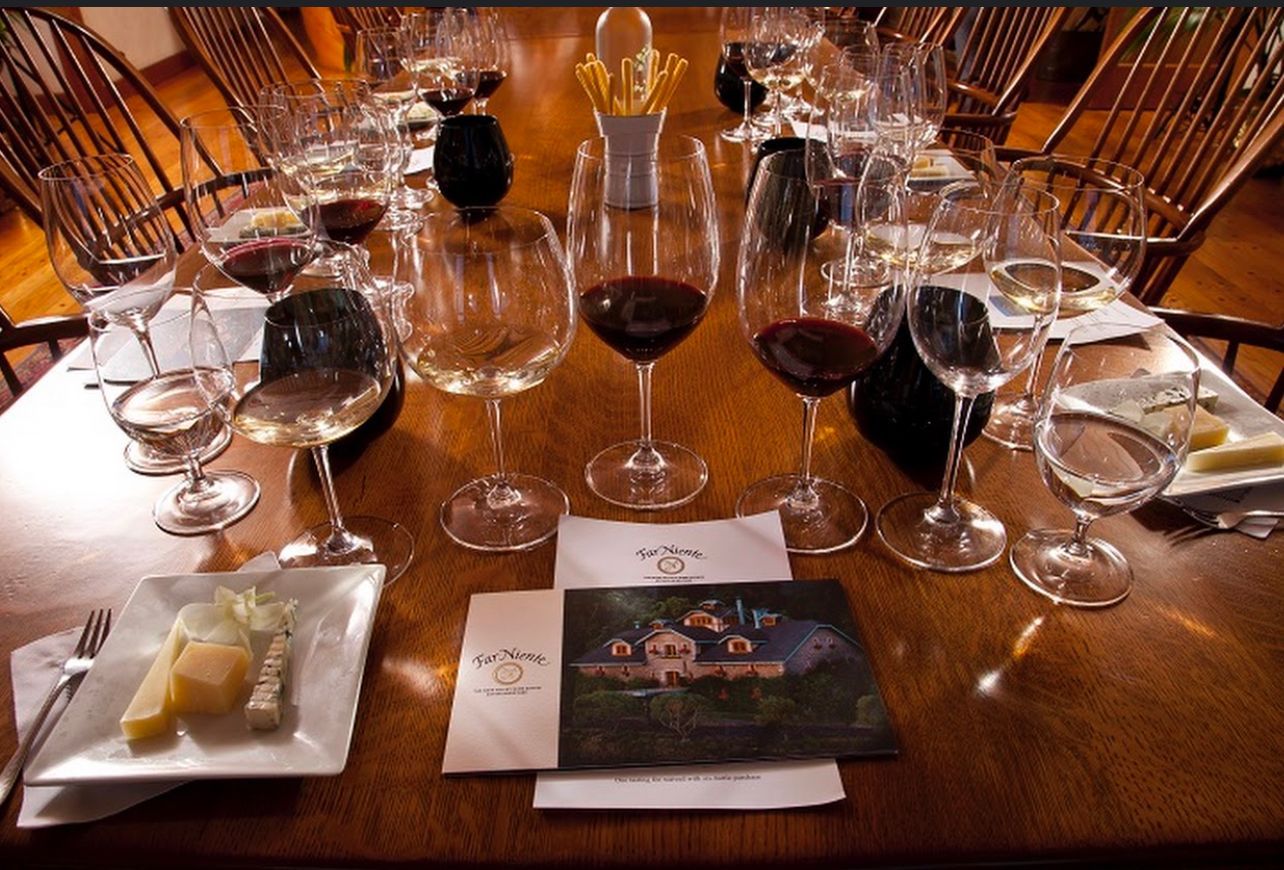 A long wooden table with lots of wine glasses on it