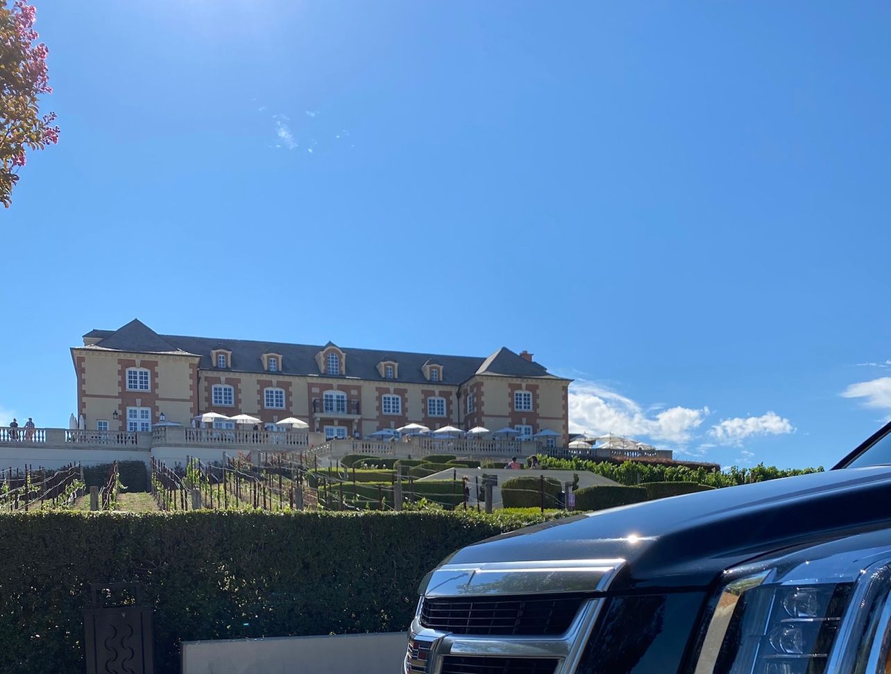 A car is parked in front of a large building.