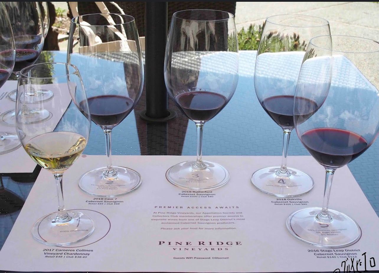 Four wine glasses filled with different types of wine on a table