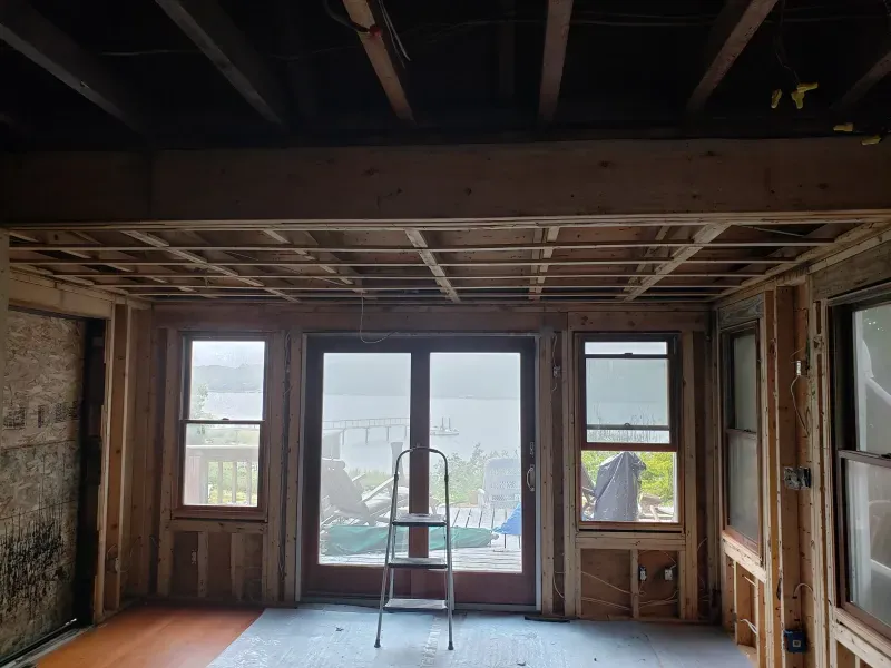 Interior room under construction, with exposed wooden framing ar