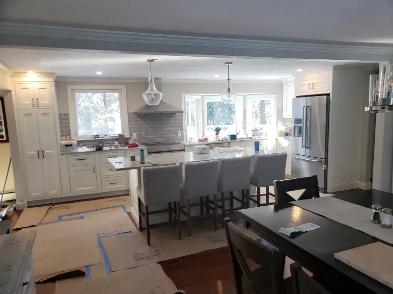 Newly renovated kitchen with a large island, stainless steel appliances, and cream cabinets.