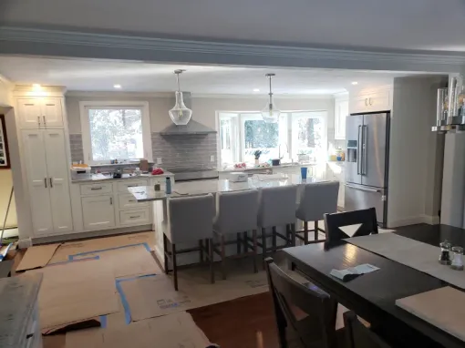 Newly renovated kitchen with a large island, stainless steel appliances, and cream cabinets.