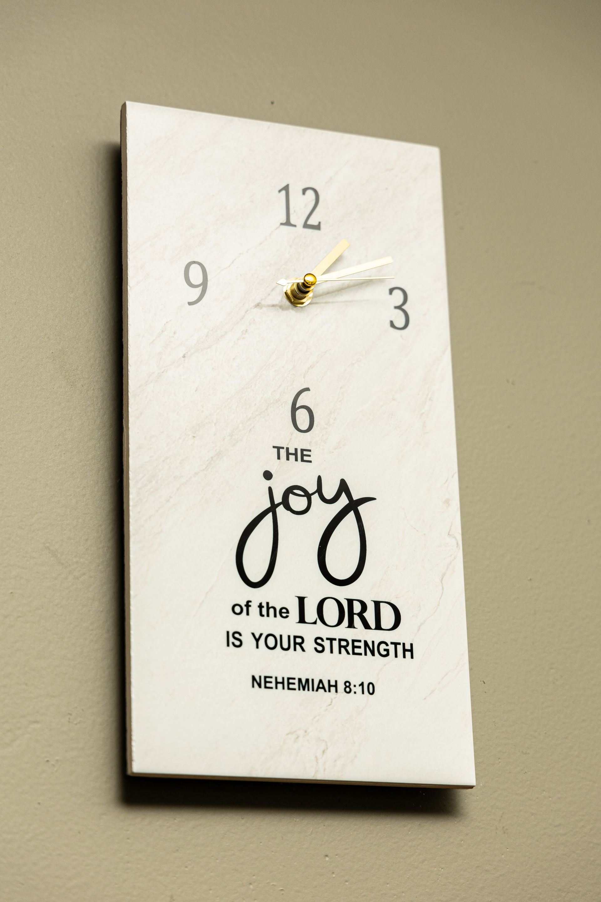 A clock with a quote on it that says the joy of the lord is your strength