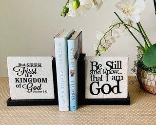 A couple of books sitting on top of a table next to a vase of flowers.
