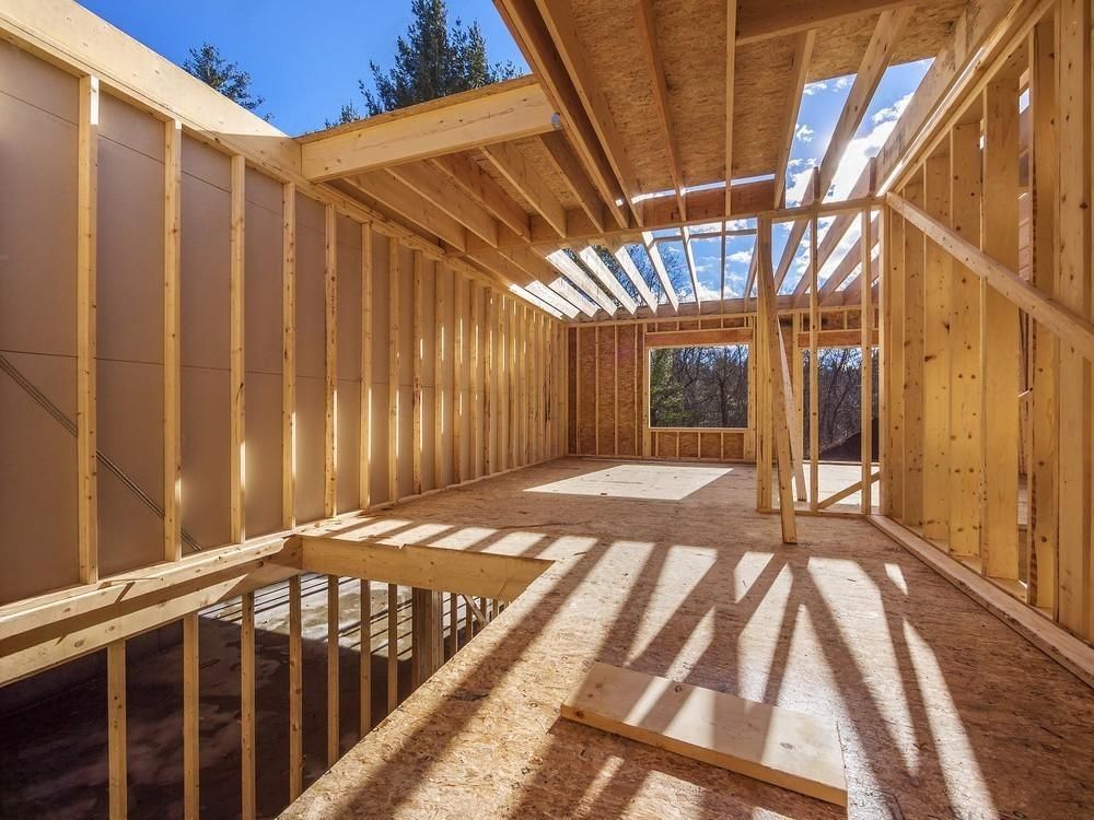 a house is being built with wooden beams and walls .