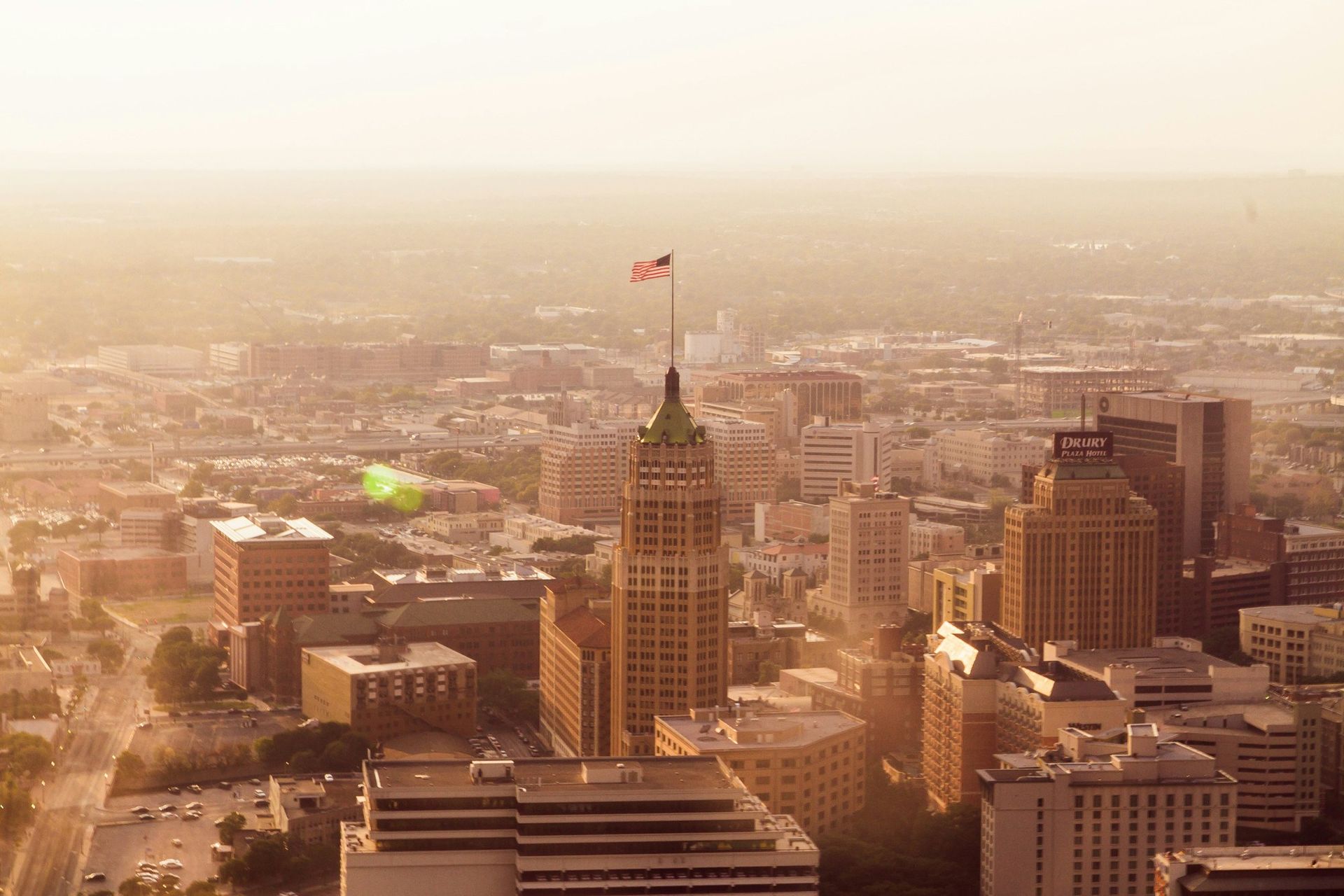 An aerial view of a San antonio with a flag on top of a building.