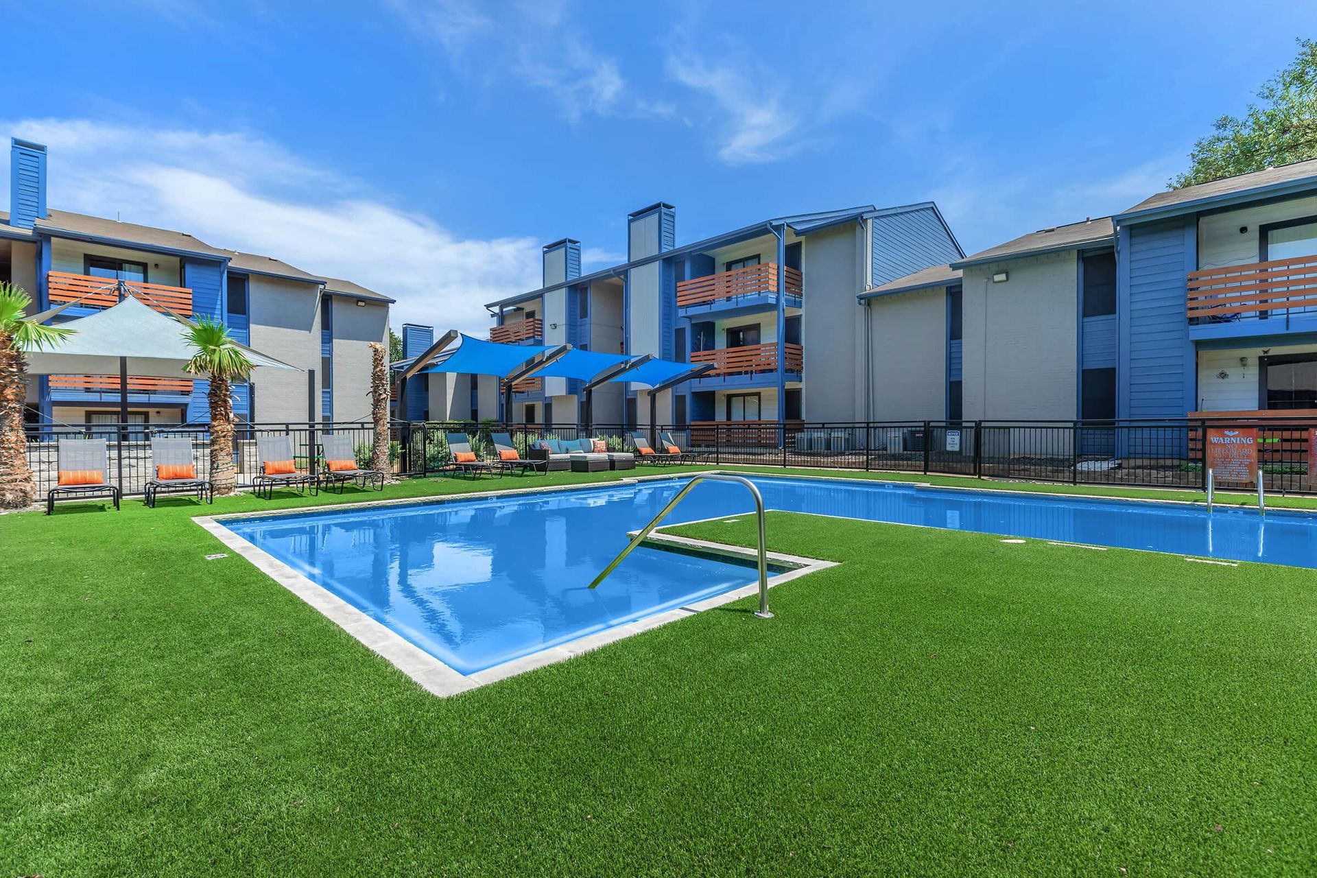 a large swimming pool is surrounded by chairs and umbrellas