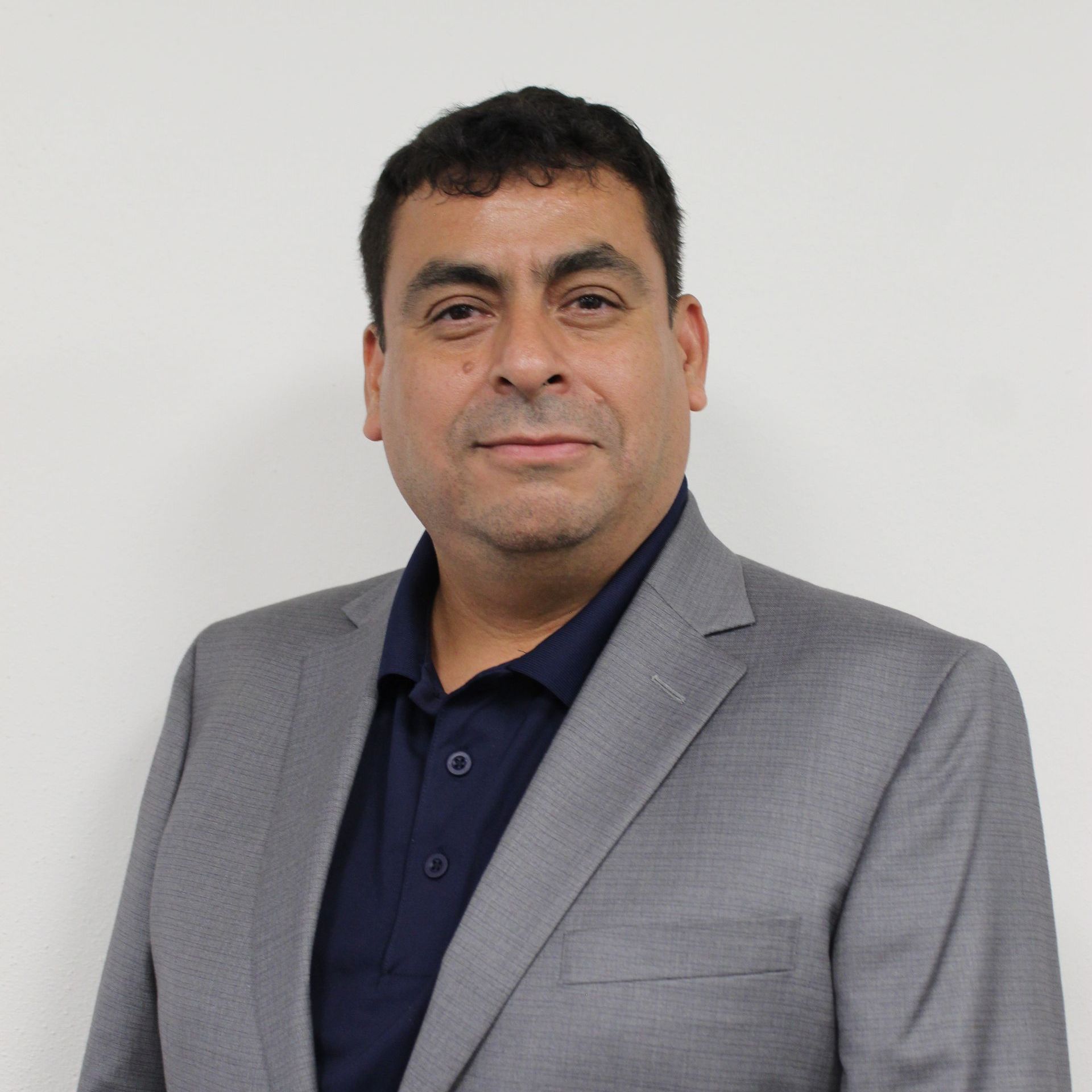 a man wearing a grey suit and a blue shirt