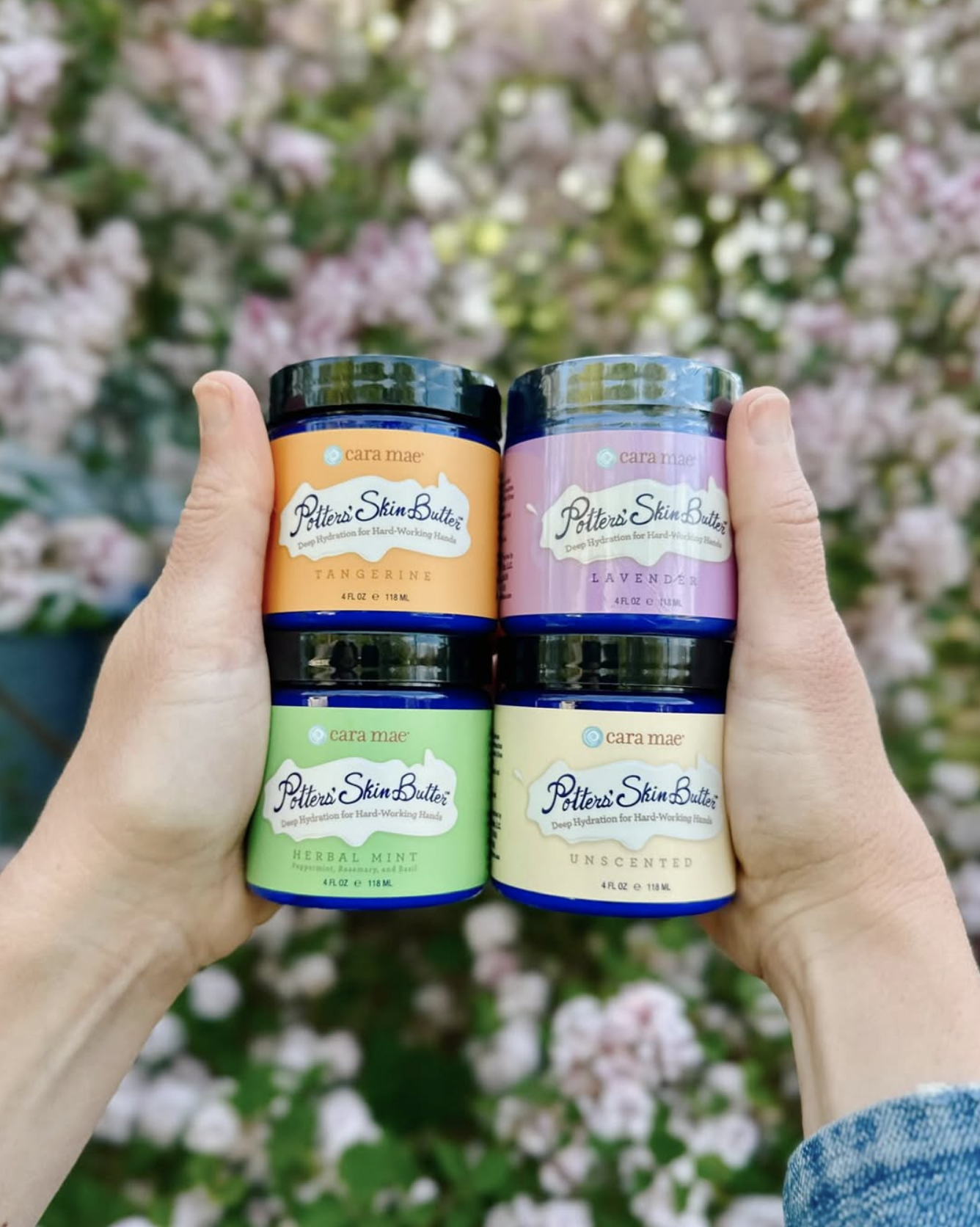Hands holding jars of Potter's Skin Butter