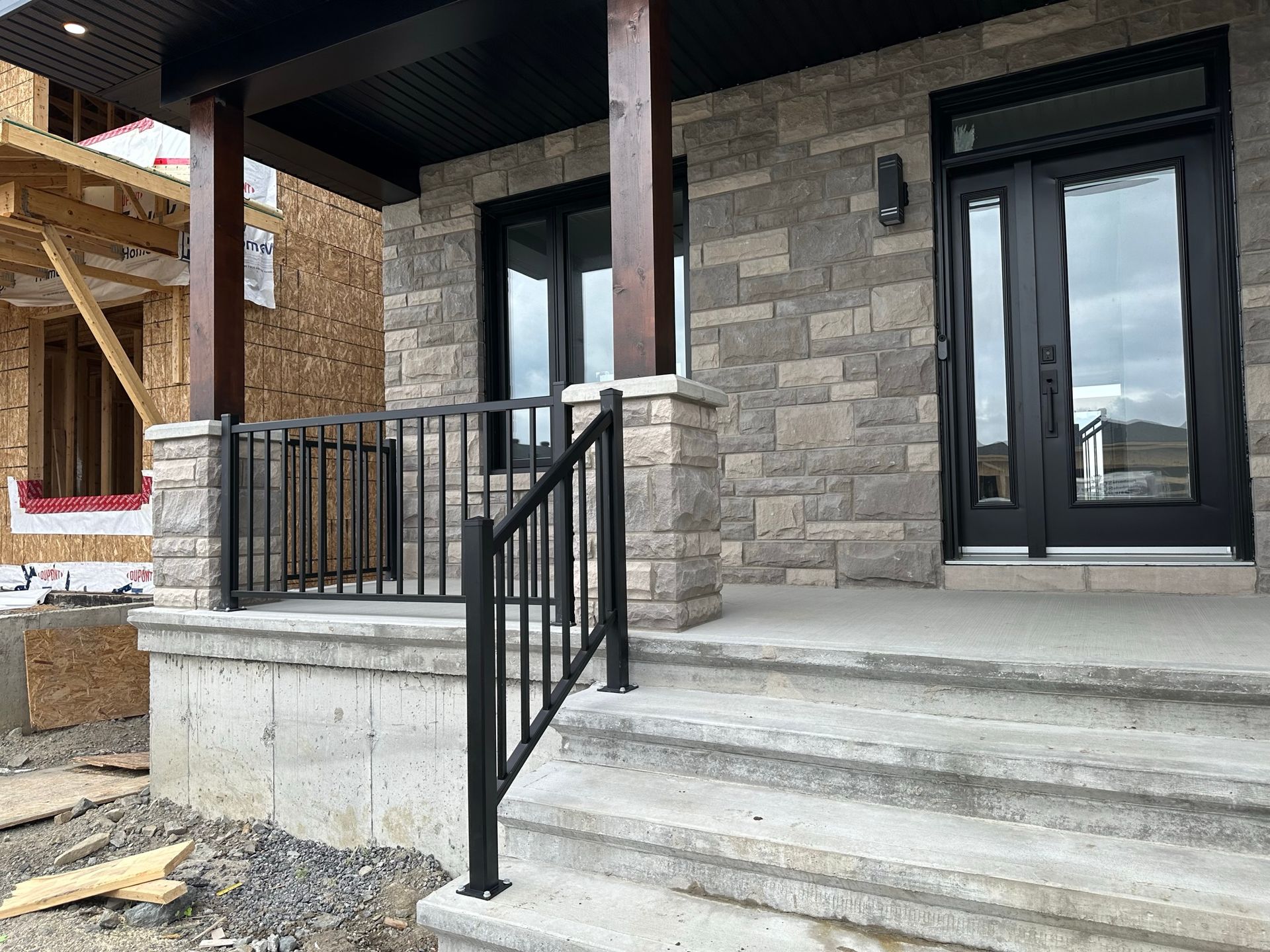 Une maison en construction avec une rampe et des escaliers noirs.