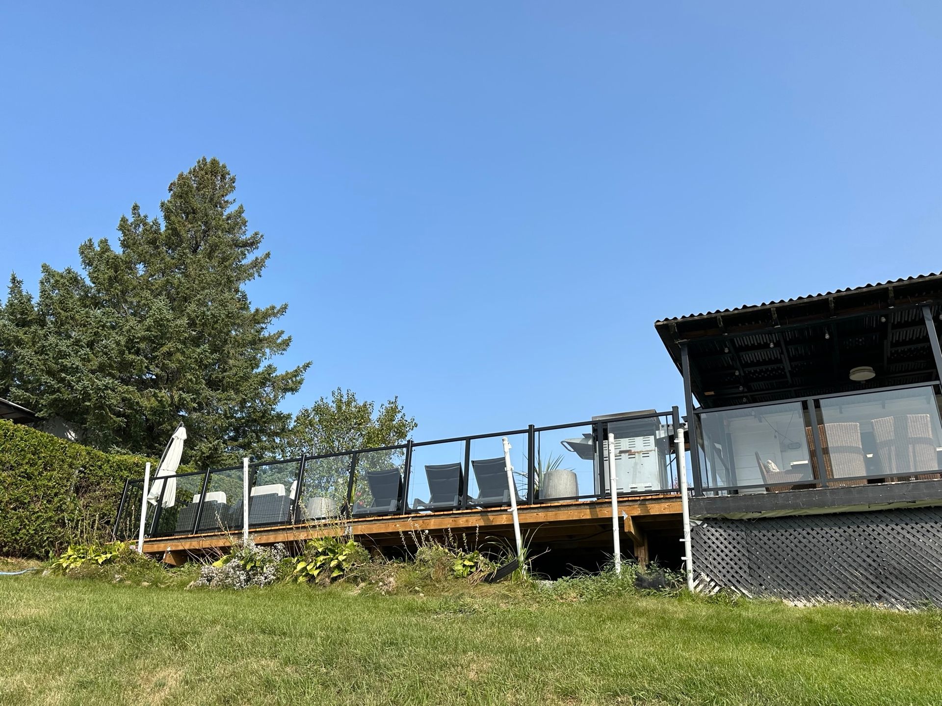 Une maison avec une grande terrasse et un ciel bleu en arrière-plan.