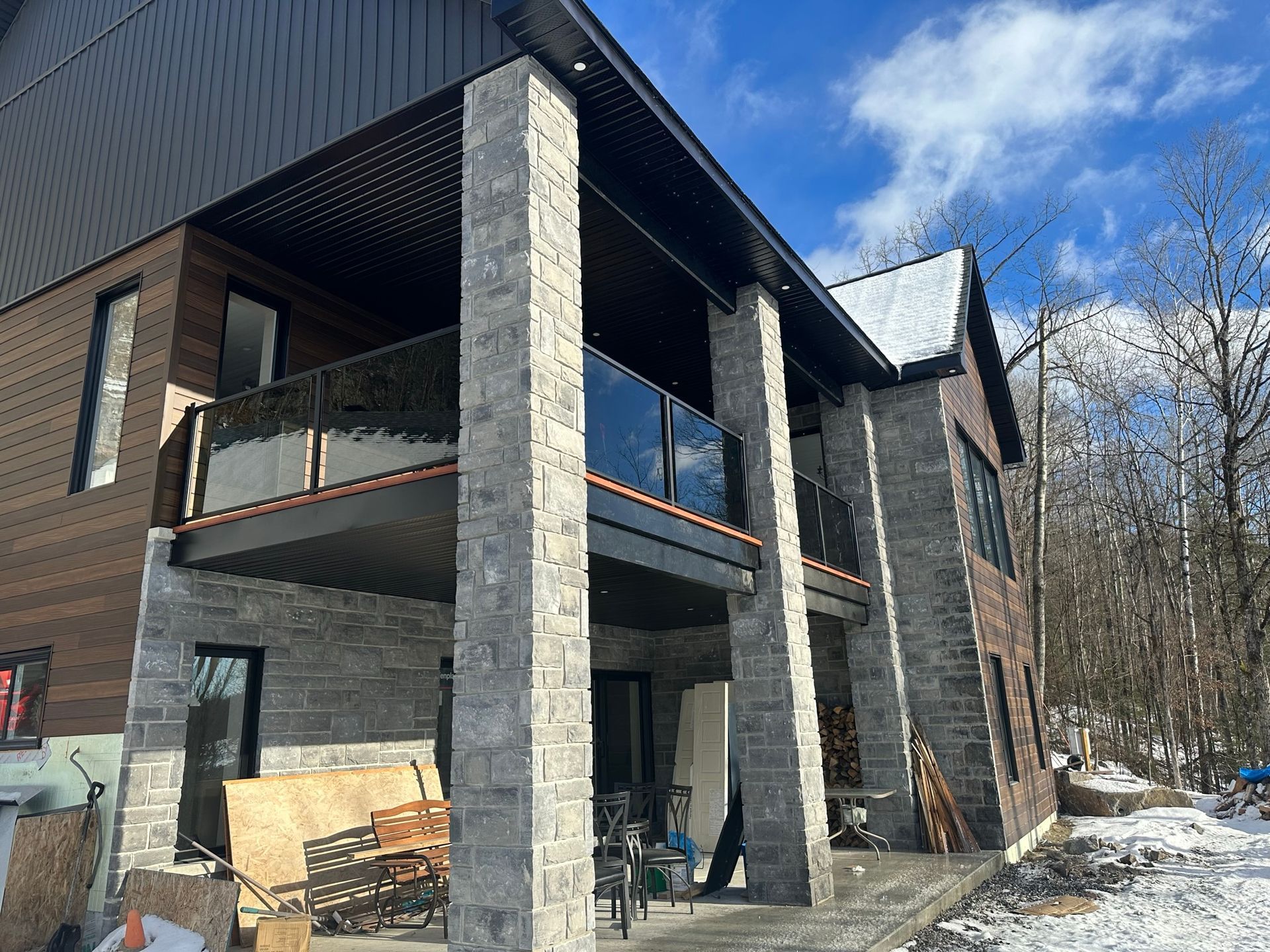 Une grande maison avec un balcon est en construction sous la neige.
