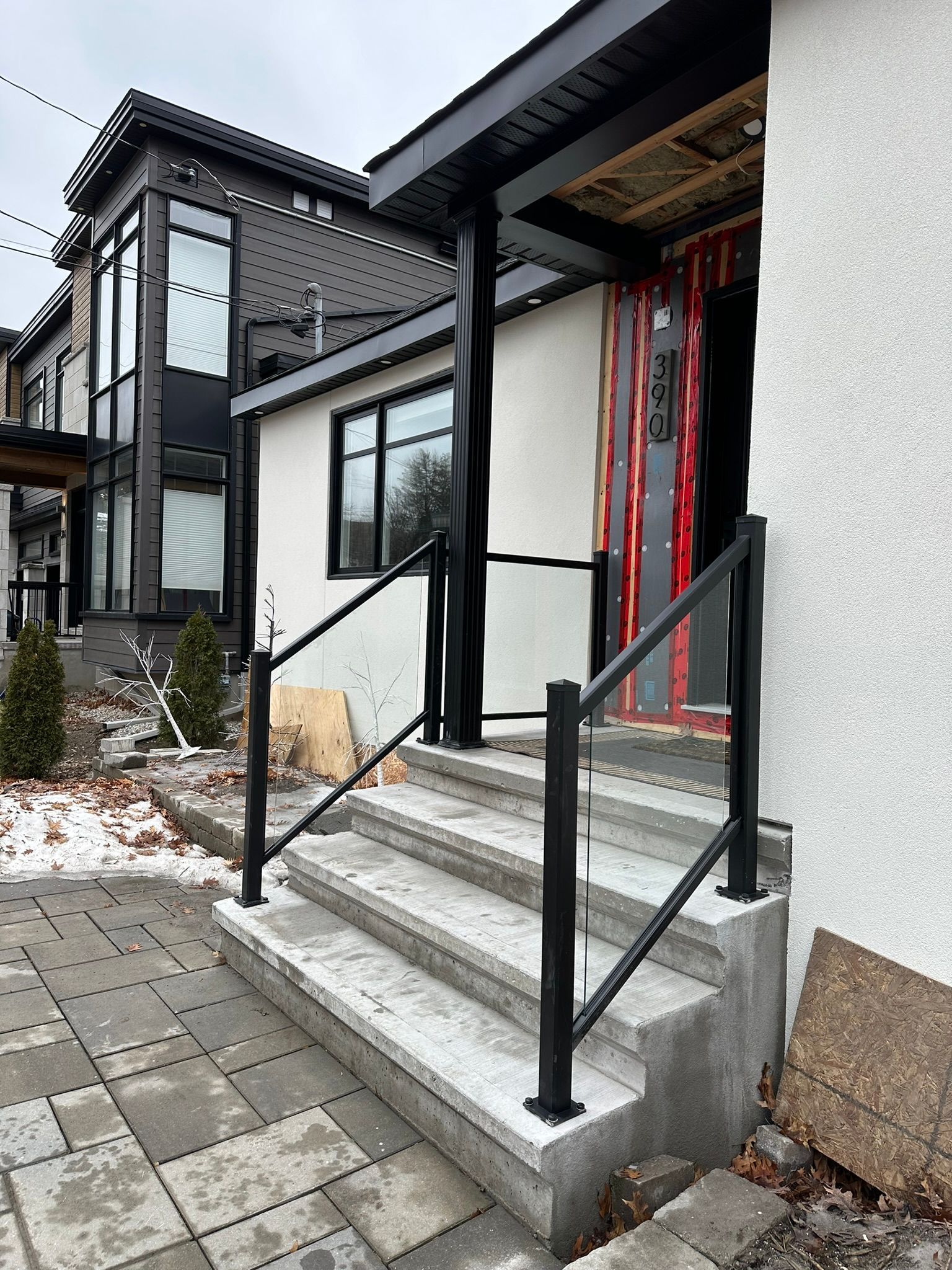 Une maison avec des escaliers menant à la porte d'entrée et une balustrade noire.