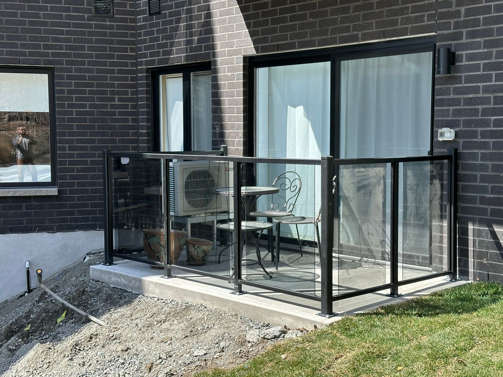 Un balcon avec une table et des chaises devant un bâtiment en briques.